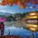 המקדש המוזהב בקיוטו יפן בעונת השלכת עם שתי נשים בלבוש מסורתי