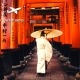 גבר בלבוש מסורתי ומטריית שמש הולך במקדש אלפי השערים בטוקיו יפן