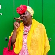 אישה-קובנית-עם-סיגר-על-רקע-קיר-ירוק