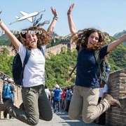 שתי נערות קופצות ושמחות לרקע החומה הגדולה בסין