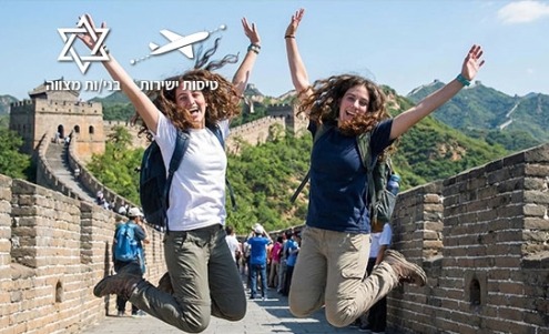 שתי נערות קופצות ושמחות לרקע החומה הגדולה בסין